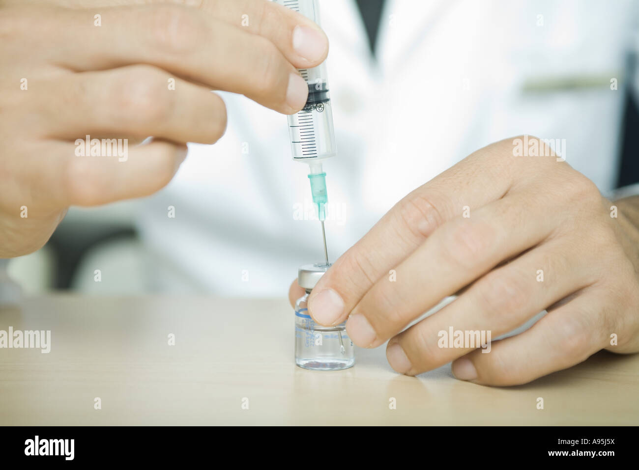 Doctor filling syringe from bottle Stock Photo Alamy