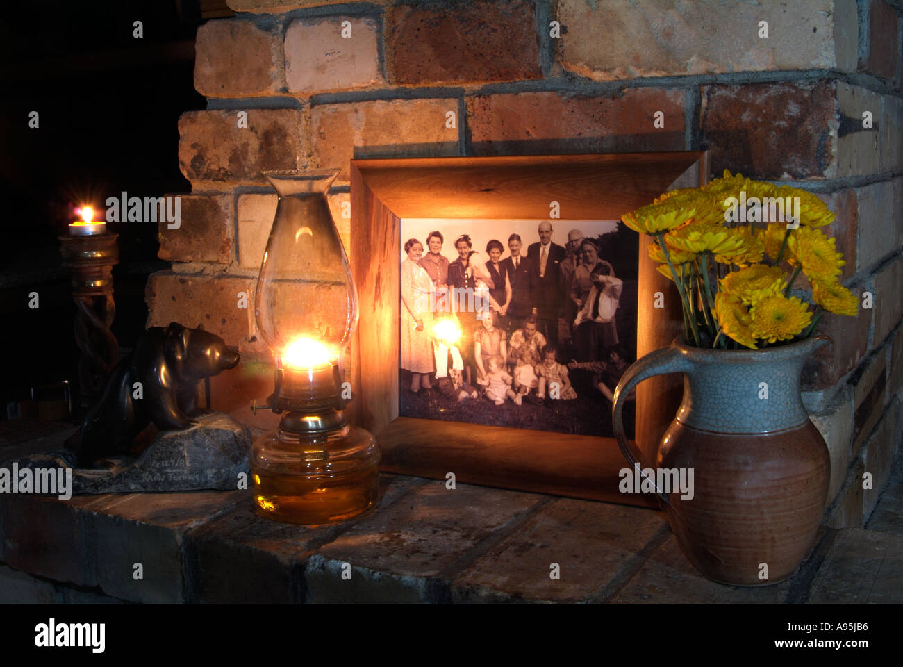 Period brick Fireplace lit by oil lamp Stock Photo