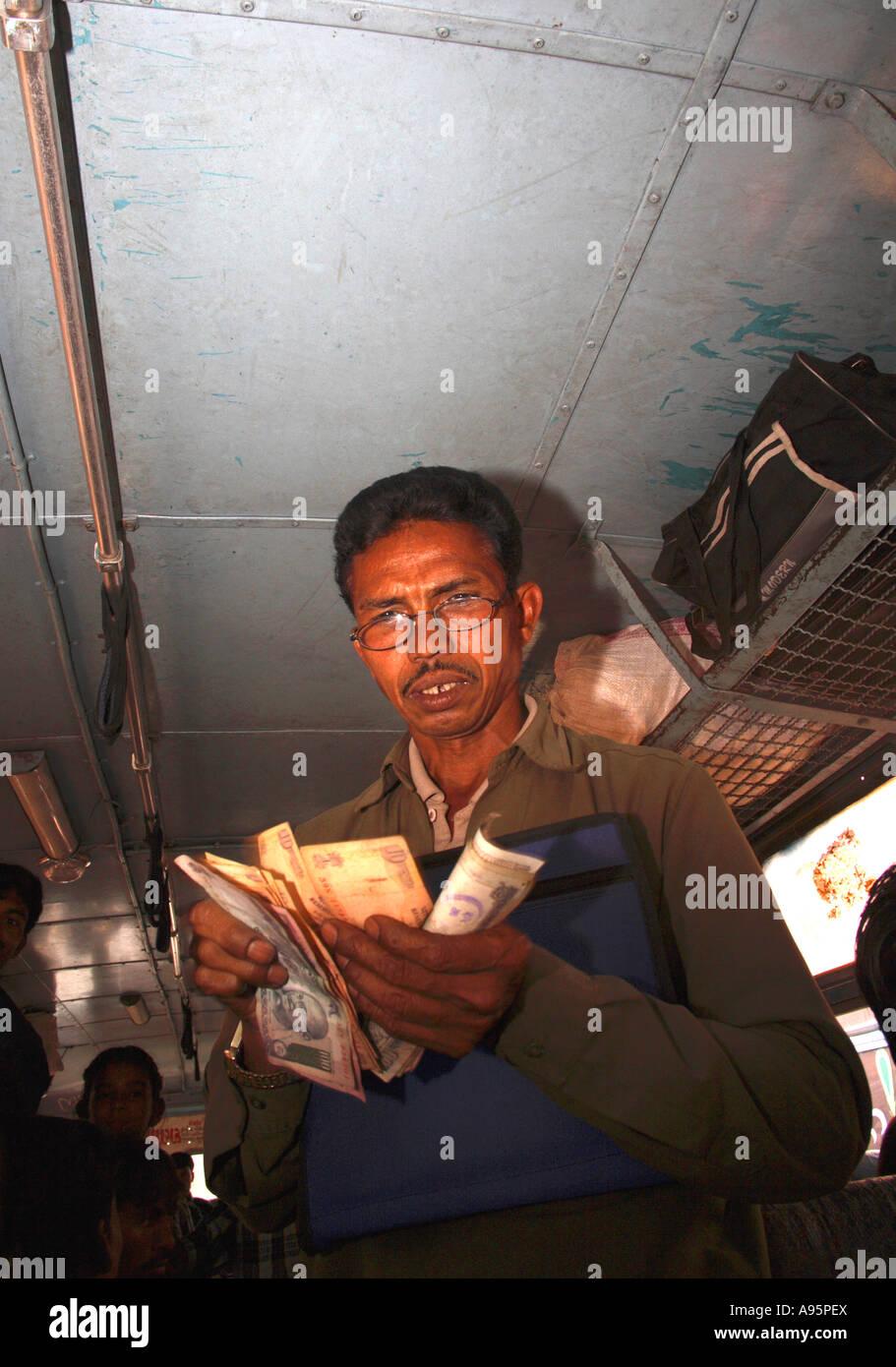 Indian Bus Conductor counting money between Vadodara to Ahmedabad, Gujarat, India Stock Photo