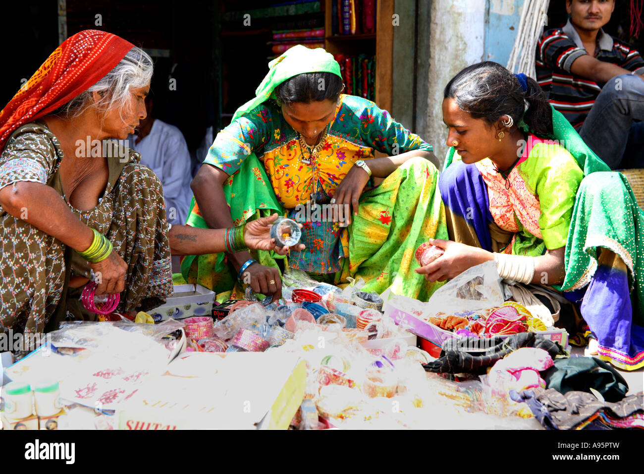 Tribal Indian women choosing jewellery from textile stall, Anjar, Kutch, Gujarat, India Stock Photo