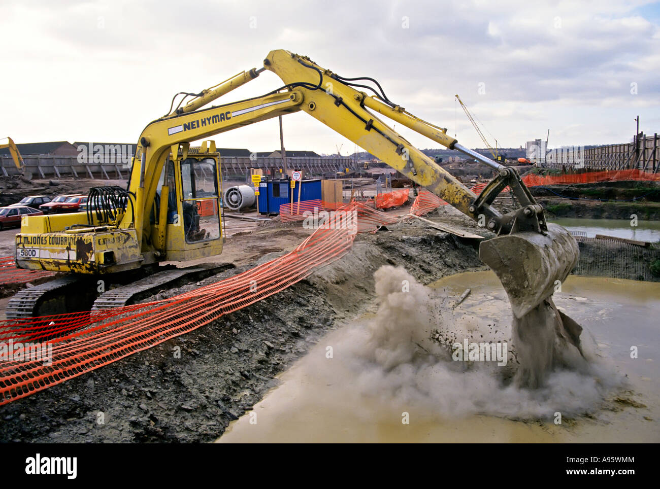 Mechanical excavator dumping concrete into pool to neutralise bentonite