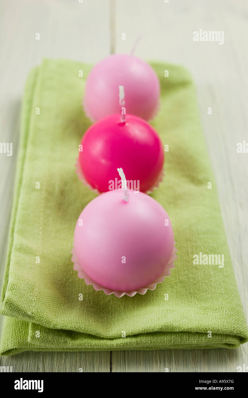 Three pink candles in a row on a green napkin Stock Photo