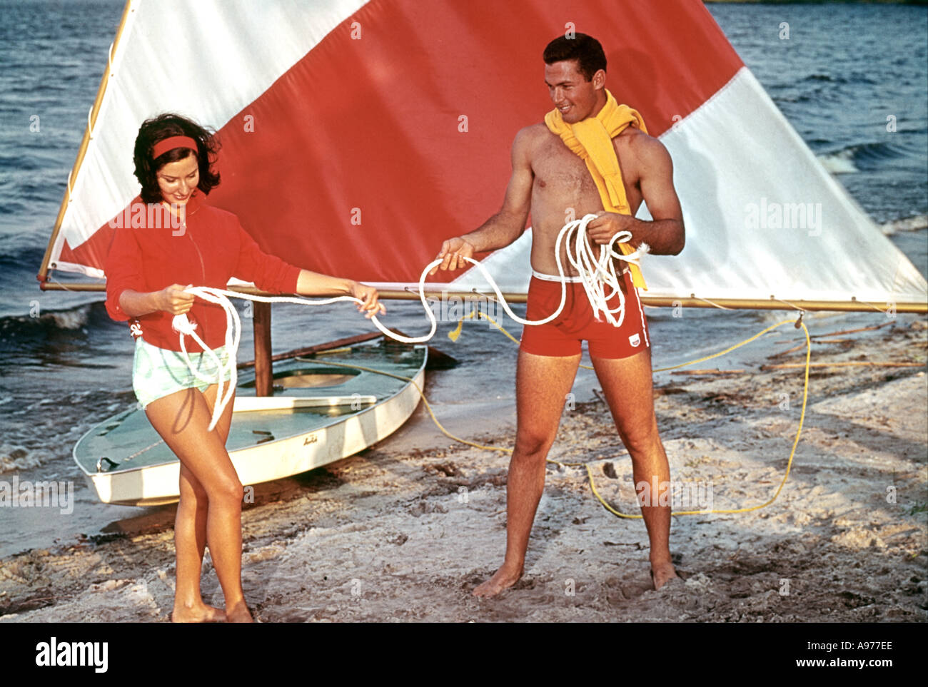 man and woman rigging small sailboat by lake Stock Photo