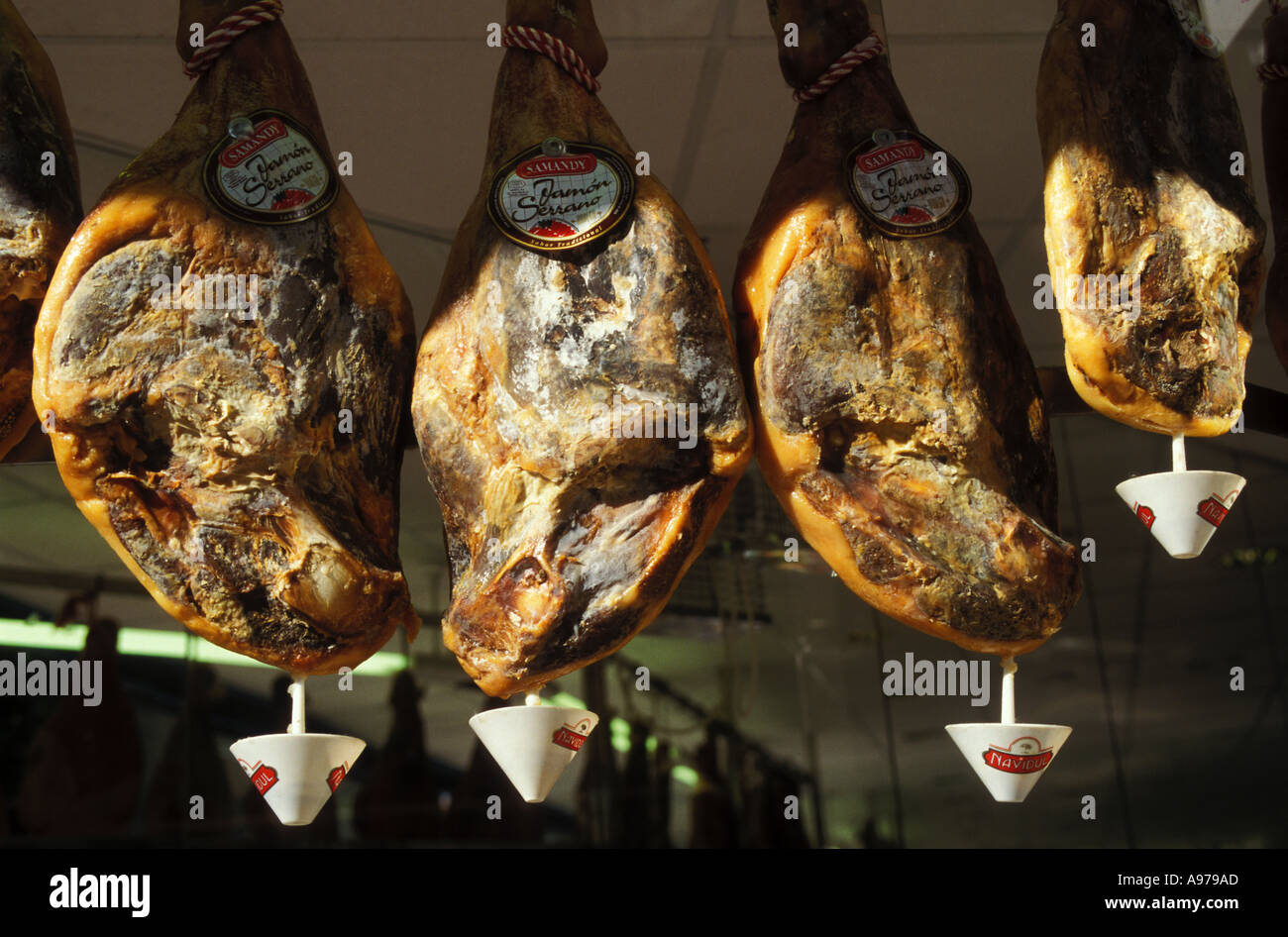 Spain Asturias Oviedo Serrano hams with fat drains hanging in shop window Stock Photo