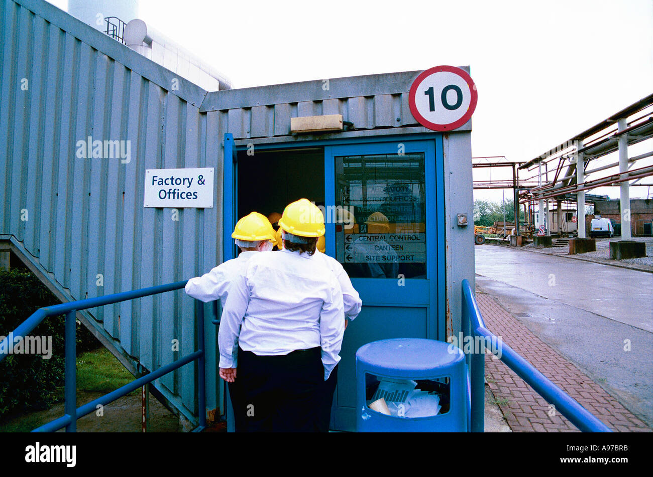 School pupils visiting factory wearing hard hats Stock Photo
