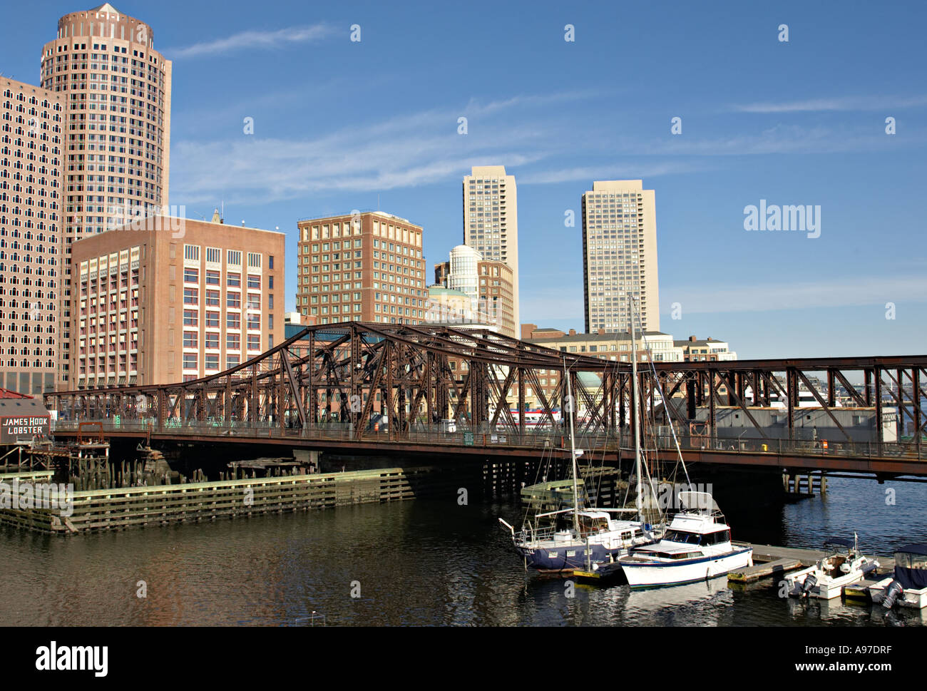 MASSACHUSETTS Boston Boats docked in inner harbor Seaport Boulevard bridge city skyline Stock Photo