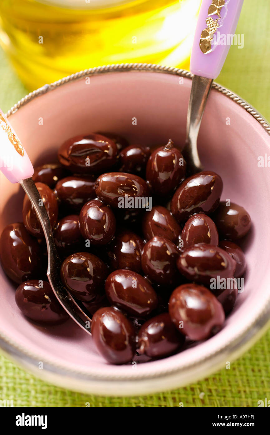 Pickled black olives in small bowl olive oil behind FoodCollection