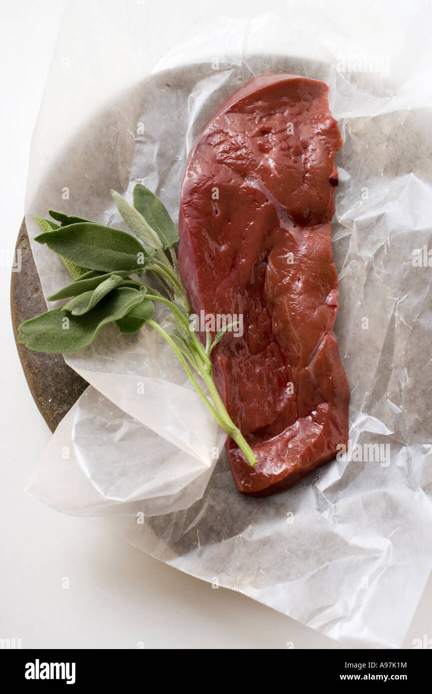 A slice of calf s liver with sage on paper FoodCollection Stock Photo