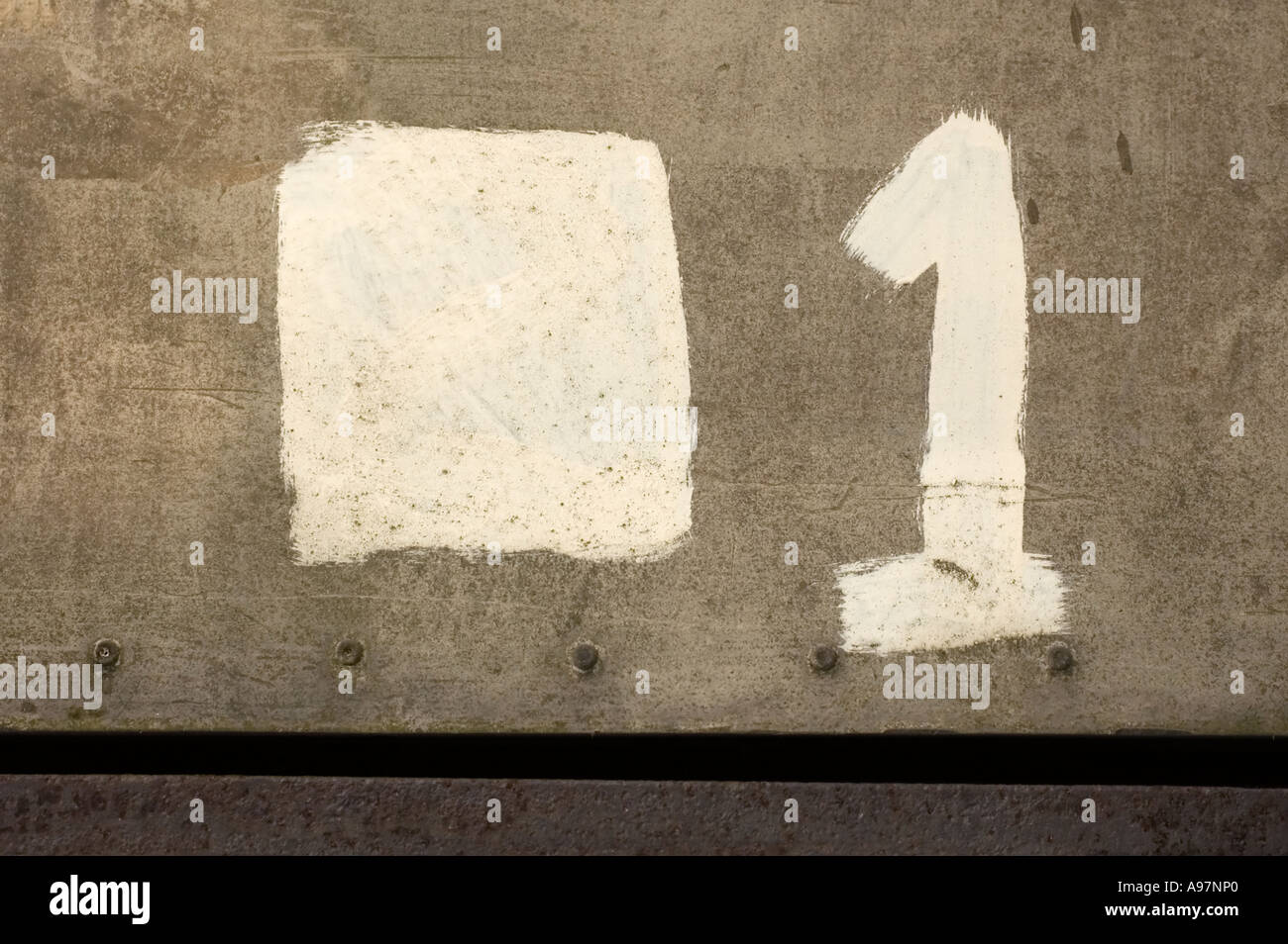 Roughly painted white number one (1) on a grey metallic background Stock Photo