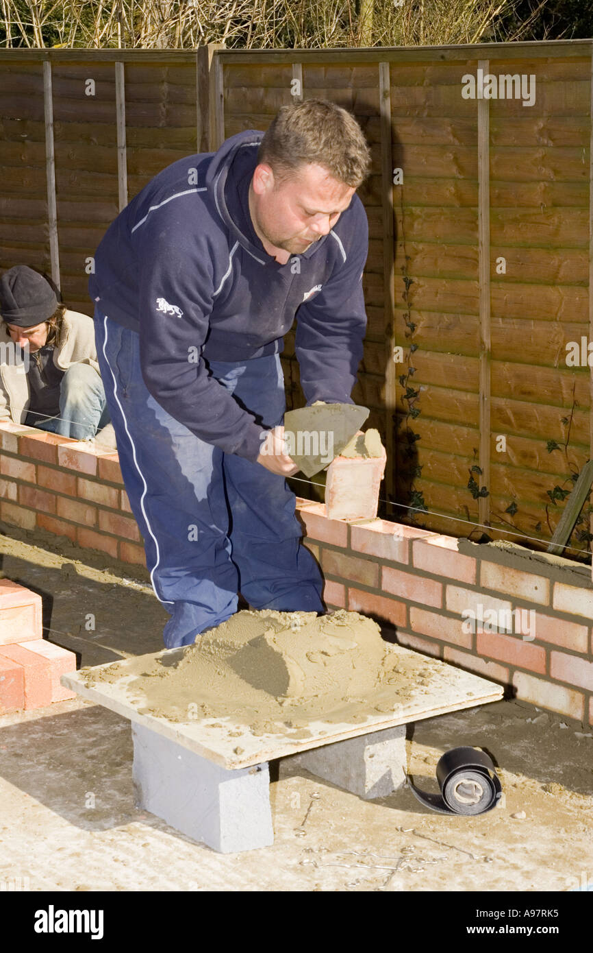 A bricklayer constructing a wall Stock Photo