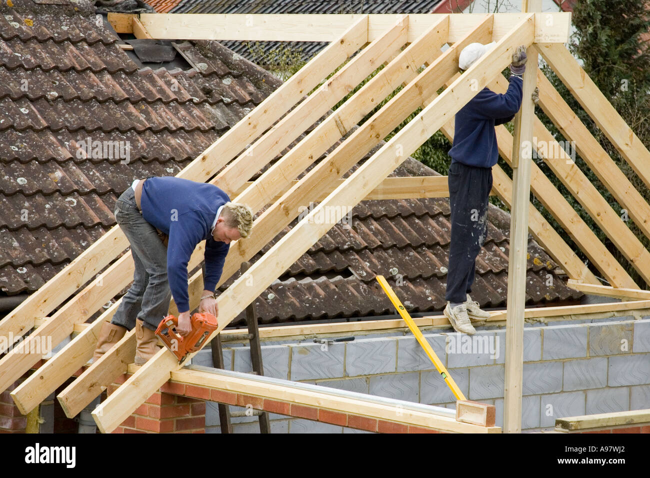 builders constructing a new roof for an extension to a home using a