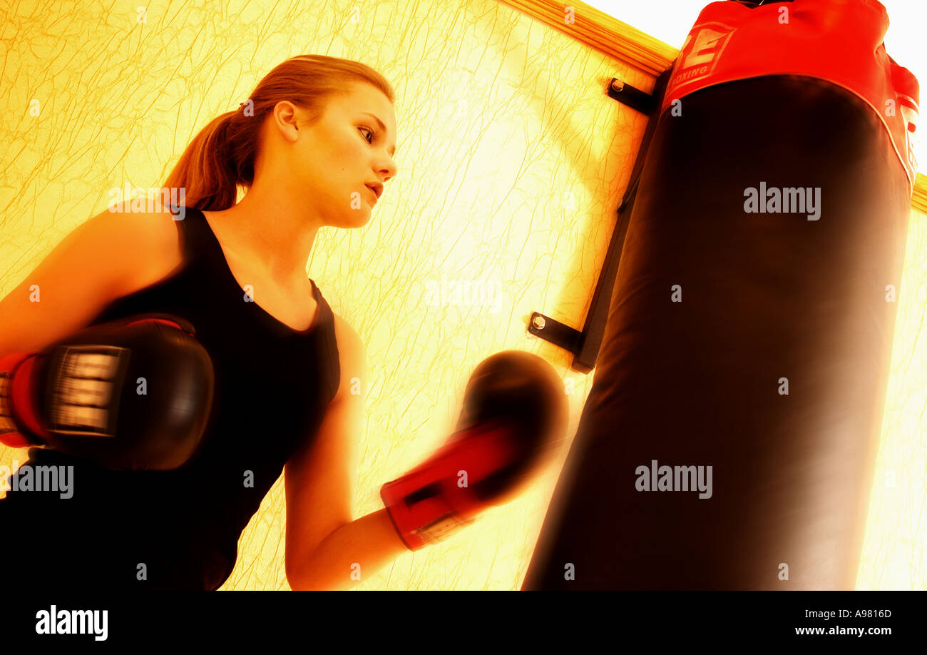 Young girl boxing punchbag in gym Stock Photo
