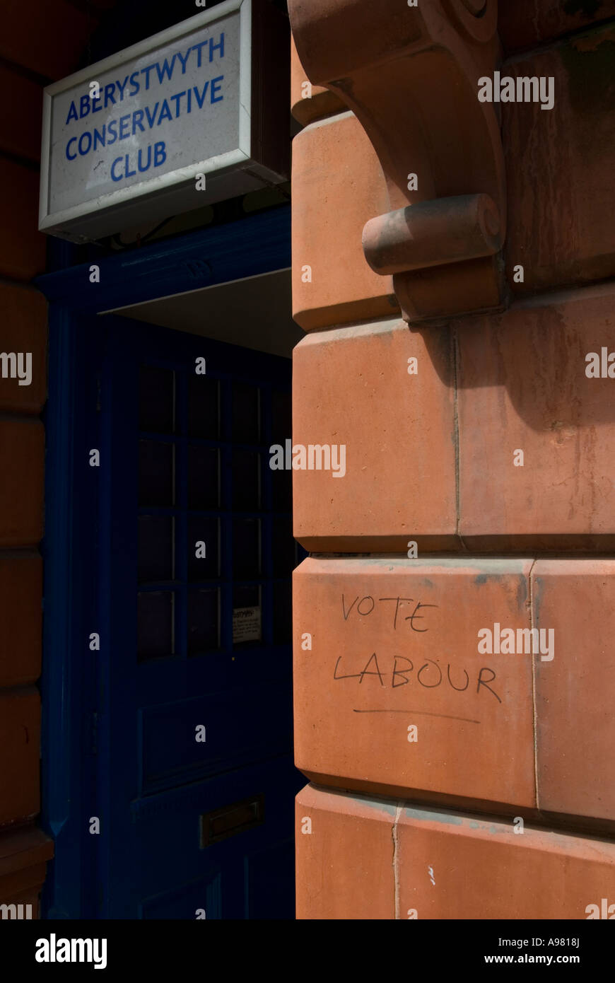 'Vote Labour' graffiti at doorway of Aberystwyth Conservative club, Wales. Stock Photo