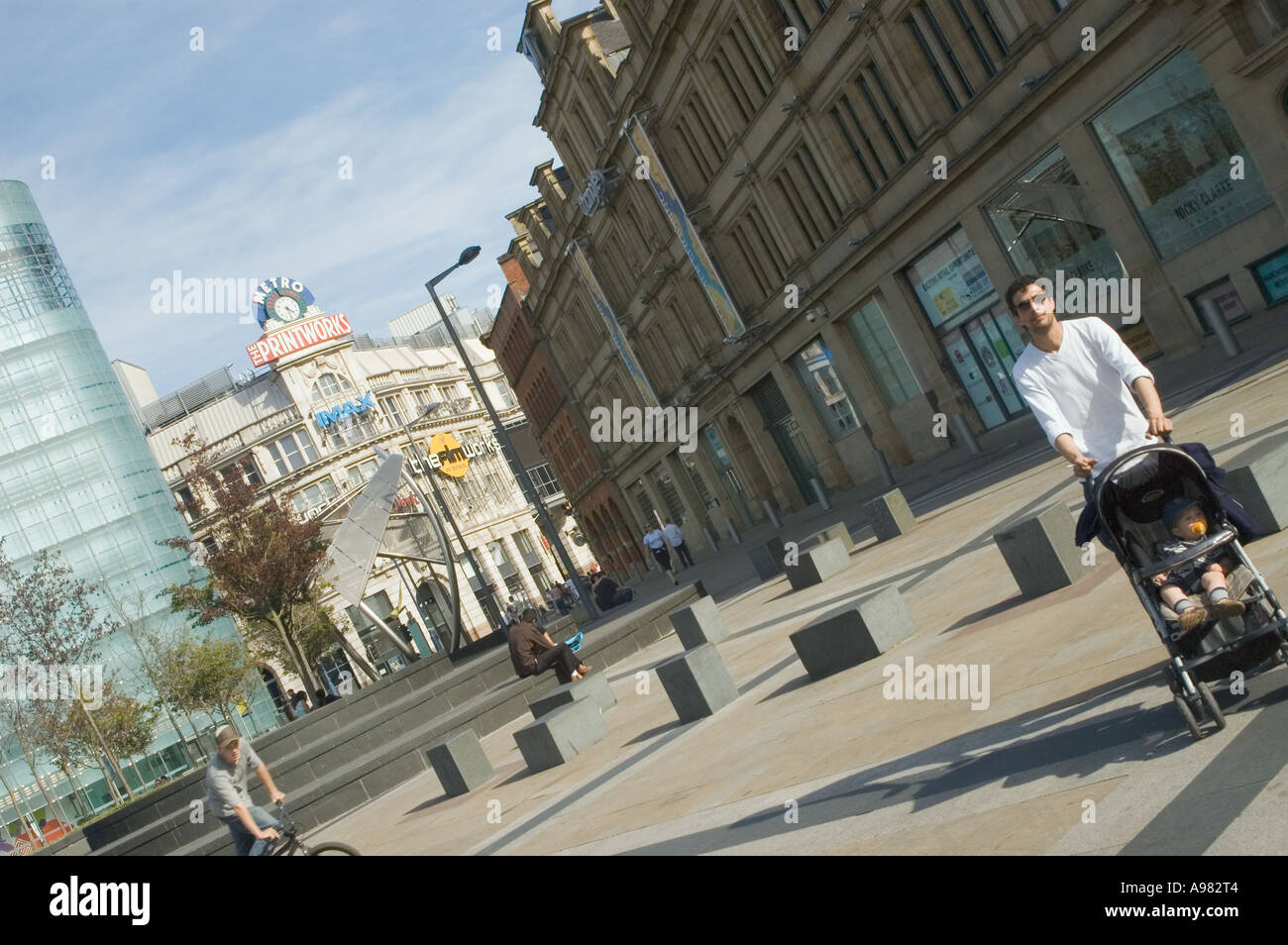man walking in manchester city centre pushing pram Stock Photo