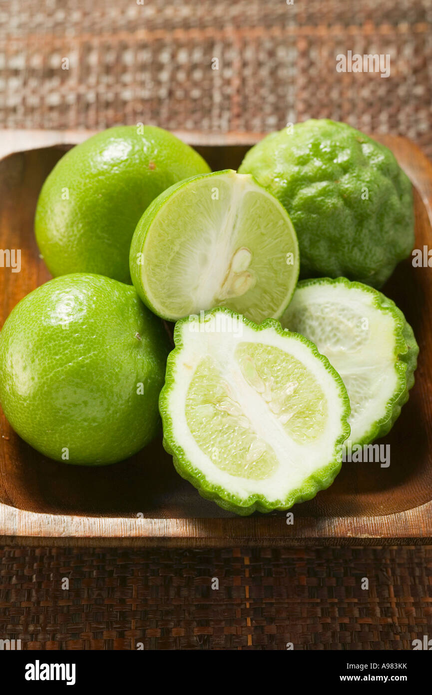Kaffir limes and limes in wooden bowl FoodCollection Stock Photo