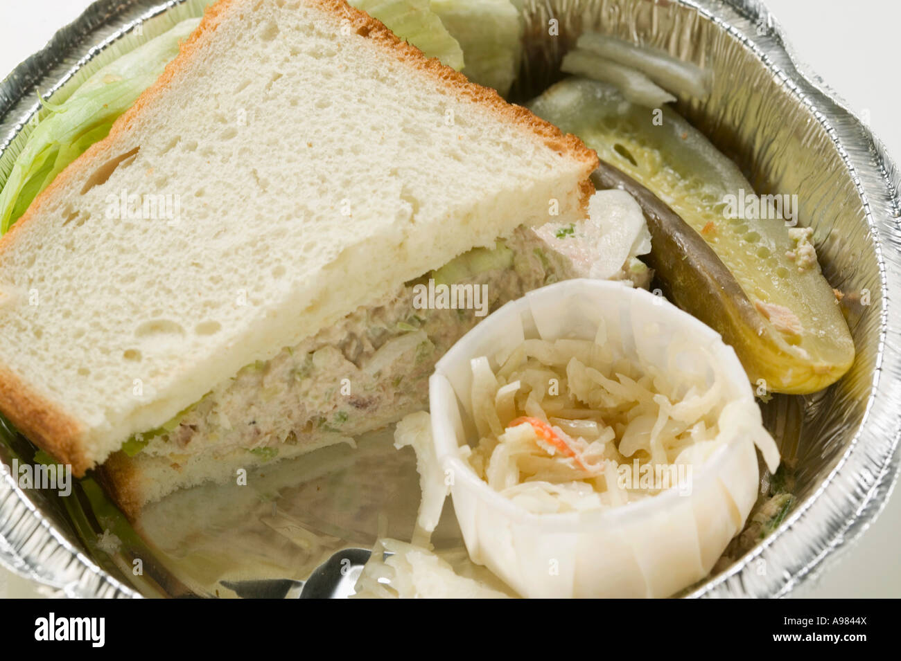 Tuna sandwich with coleslaw and gherkin in lunch box FoodCollection