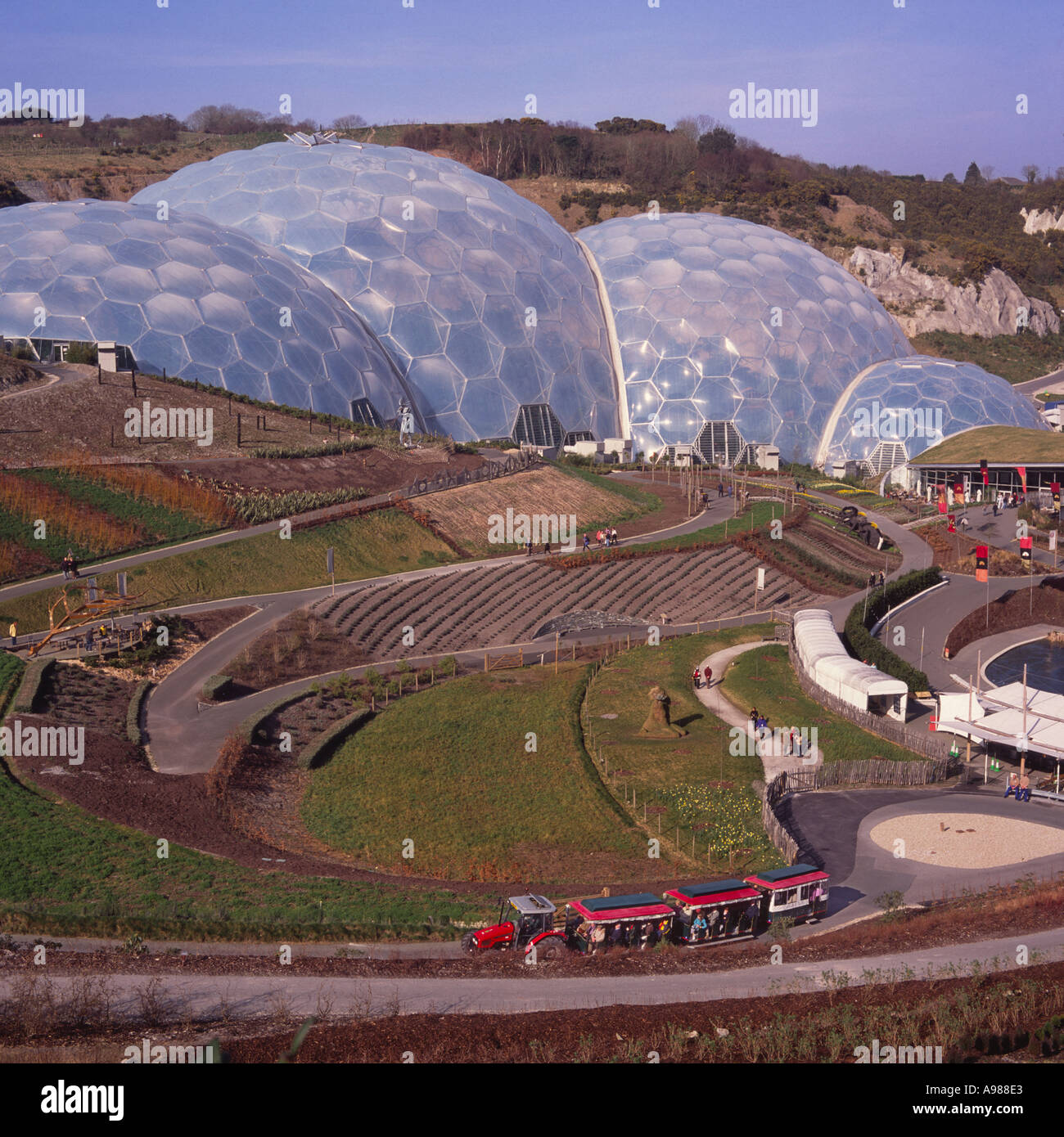 Landscape view of people walking on grounds by Humid Tropics Biome domes of The Eden Project Cornwall England Stock Photo