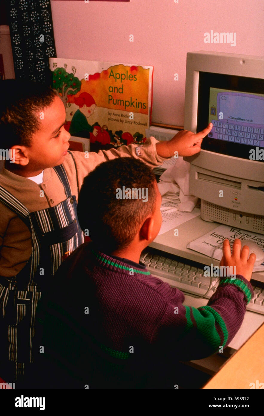 Four year old boys playing with computer Stock Photo