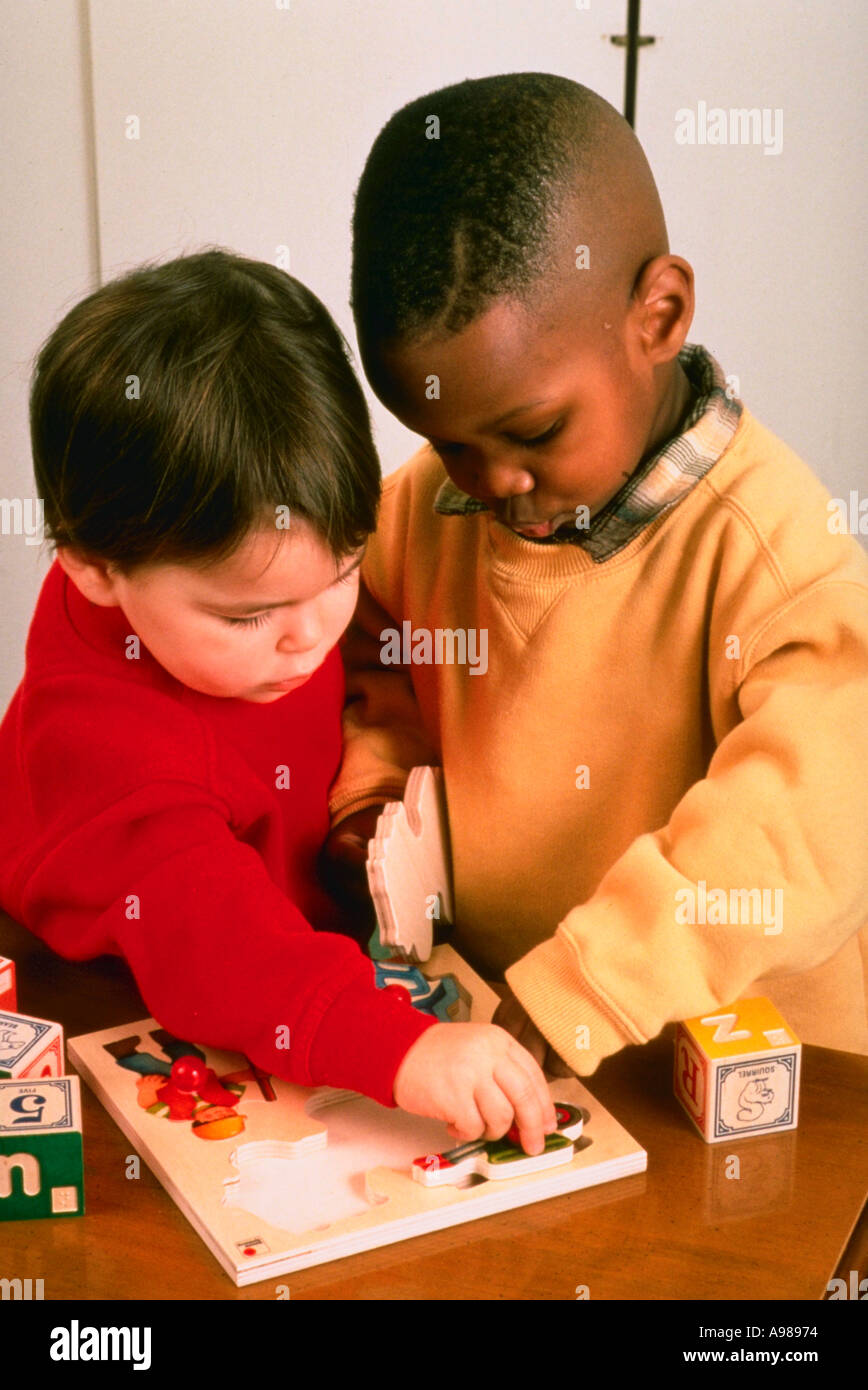 Two young children boy and girl playing with puzzle Stock Photo