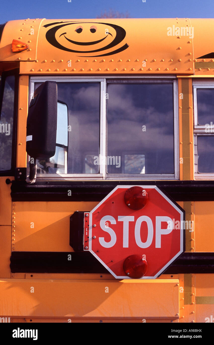 Stop: An illuminated swing out stop sign mounted on the side of a Bluebird school bus, New Hamburg, Ontario, Canada Stock Photo