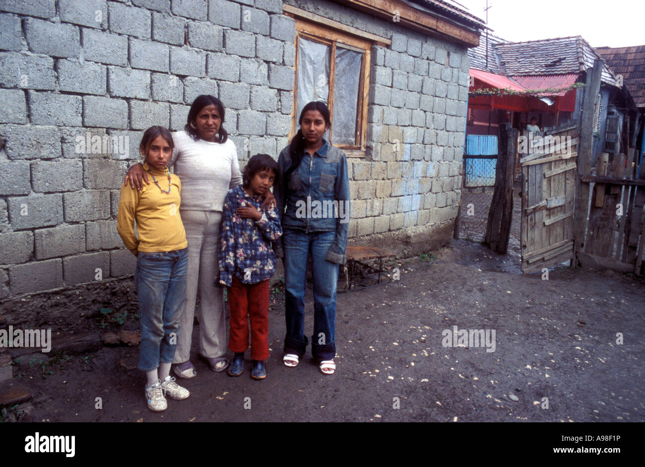 Mother and three daughters posing outside block house in Transylvanian Gypsy village of Soard. Stock Photo