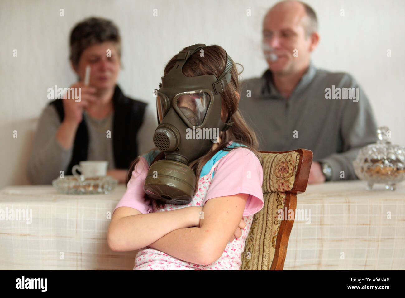 a young girl is demonstratively wearing a gas mask because her parents