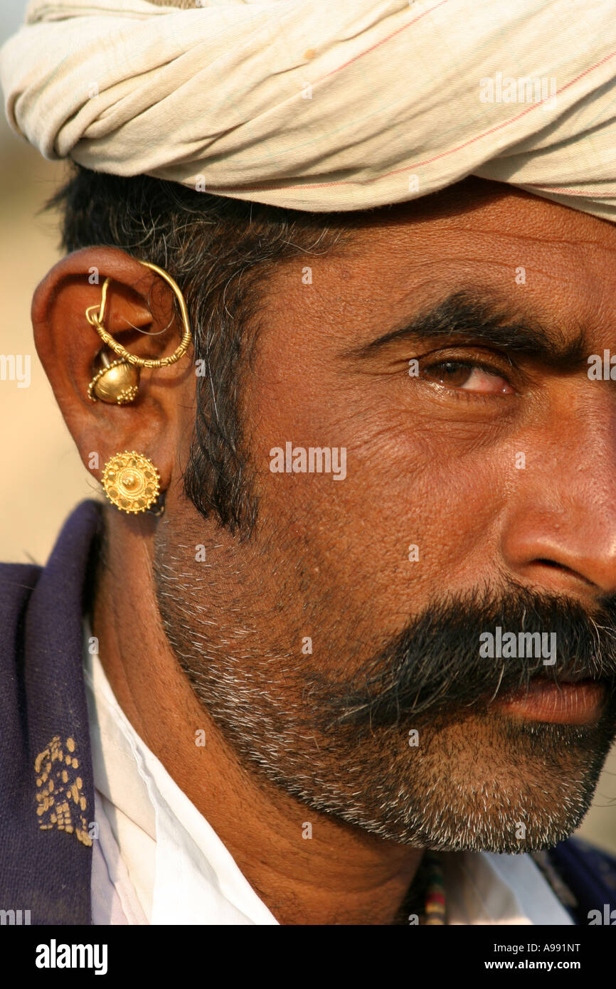 Gujarati Tribal man wearing typical mix of gold earrings Stock Photo