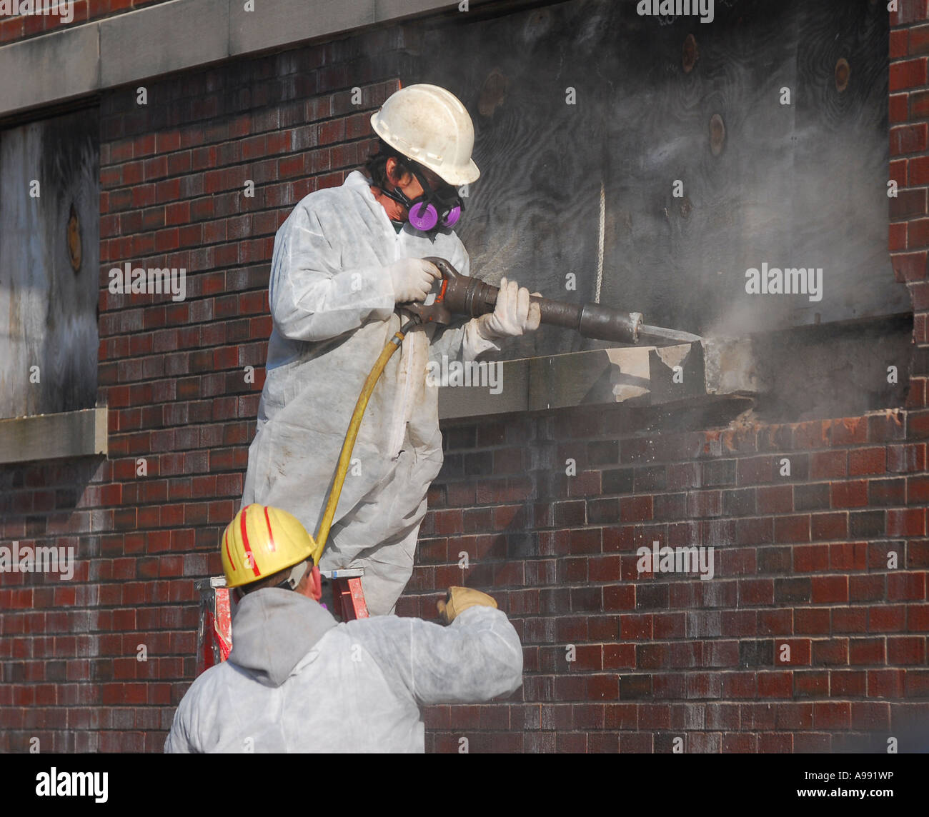 Workers use a pneumatic jackhammer to demolish a building Stock Photo