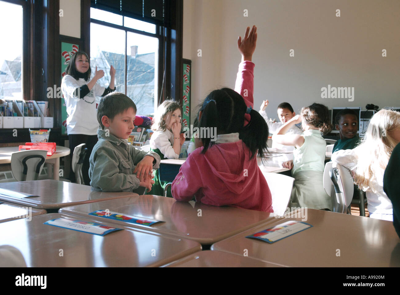 Child raising hand in classroom, New Haven Connecticut USA Stock Photo