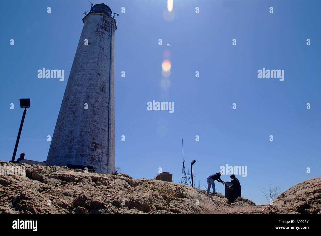Volunteers clean up a beach next to a lighthouse in New Haven