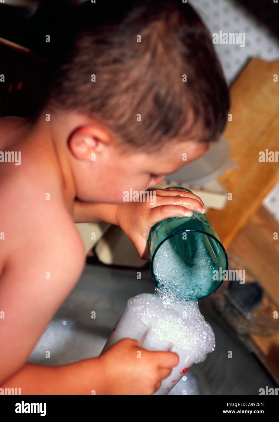 3 yr old doing dishes Stock Photo