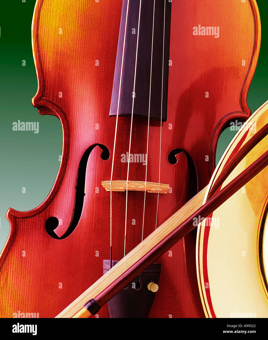 Close up still life of a violin and a bow resting against the bell of a horn Stock Photo
