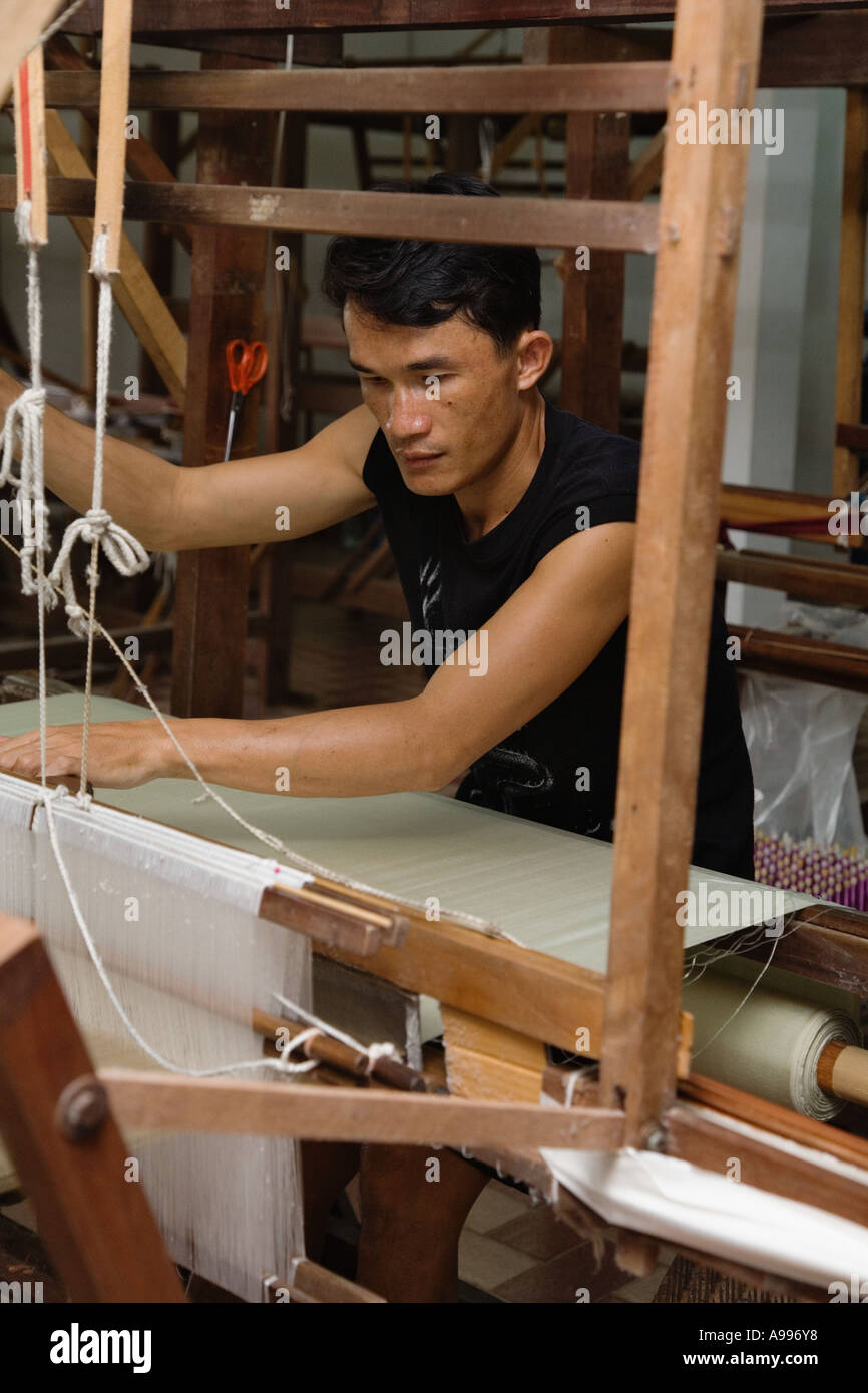 Young man producing silk on an upright loom factory in Bo Sang Thailand. Stock Photo