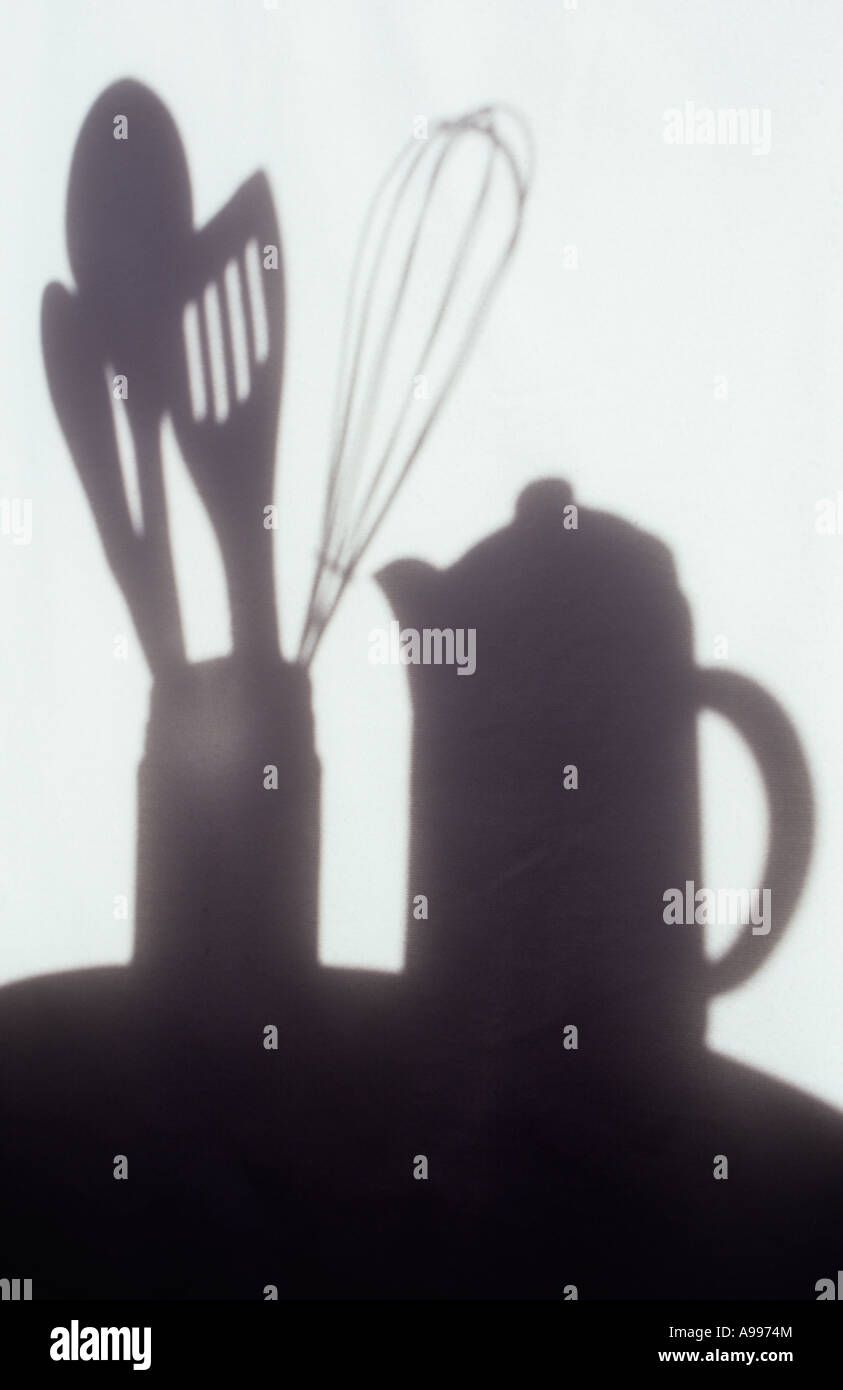Shadow in warm light on pale cloth or curtain of coffee pot and kitchen utensils in jar Stock Photo