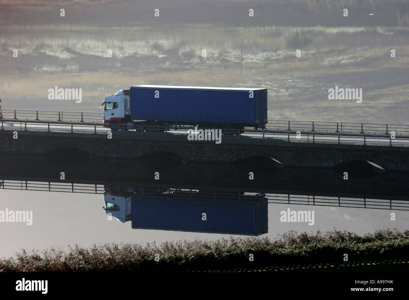 An articulated lorry reflected on a lake in the Pennines, England. Stock Photo