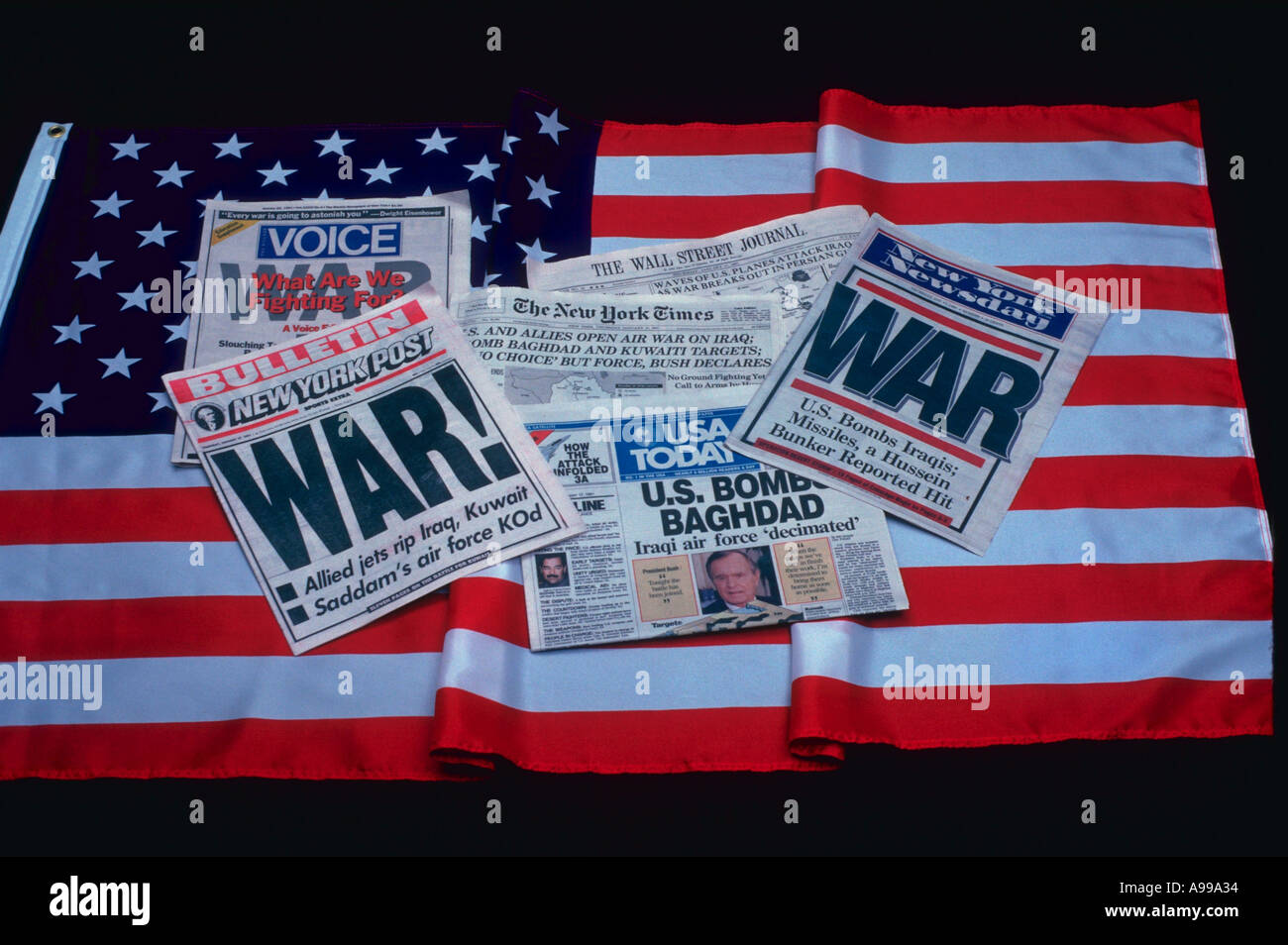 Still life of several newspapers with headlines announcing the Gulf War with Iraq laying on an American flag Stock Photo