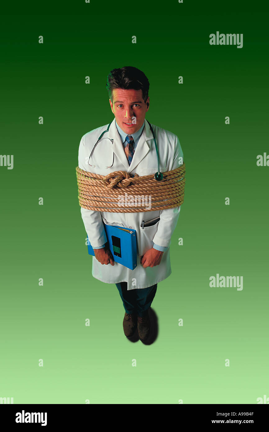 A young male doctor with a stethoscope and chart standing tied up with