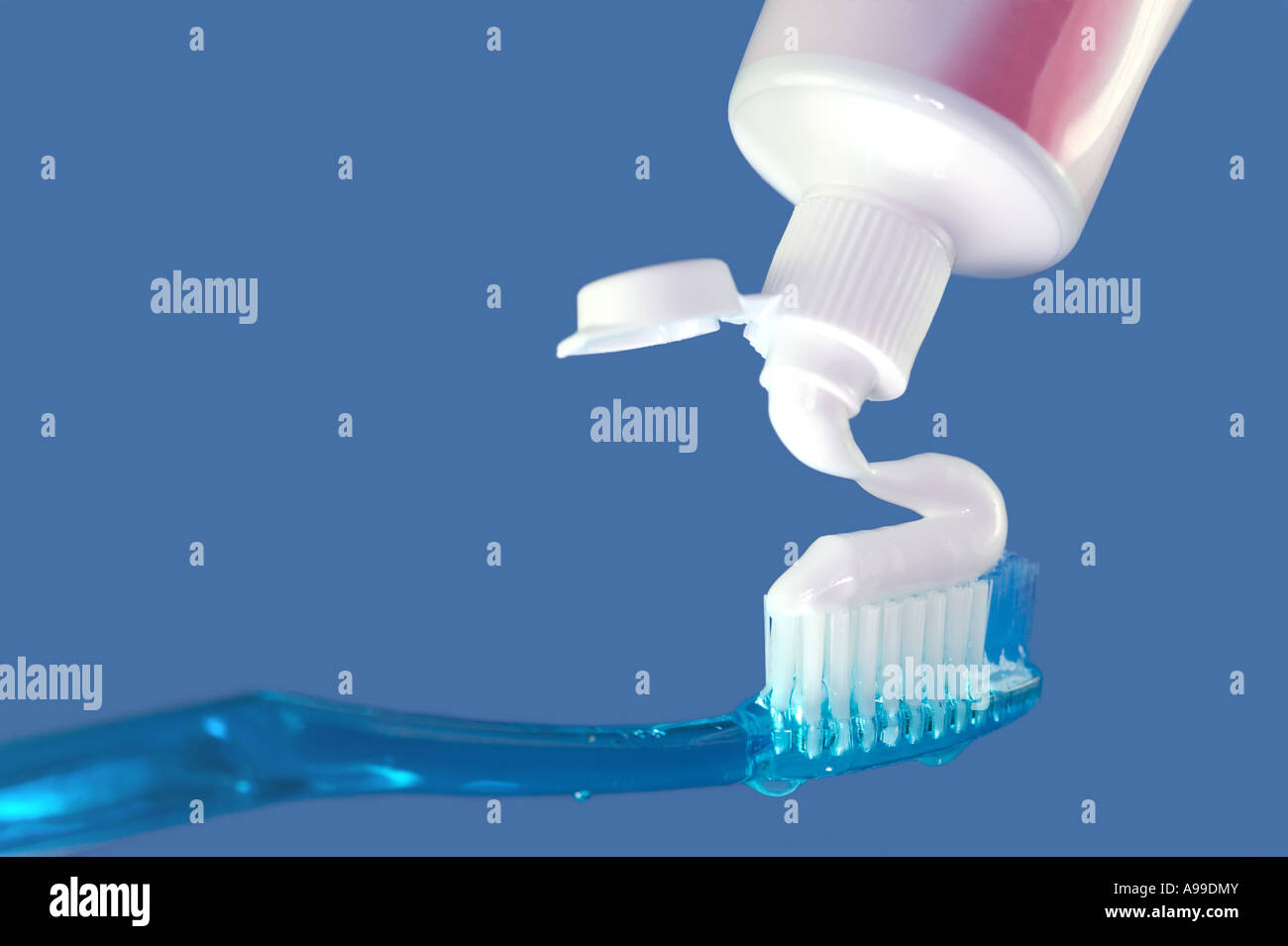 Blue Toothbrush and toothpaste on a blue background Stock Photo