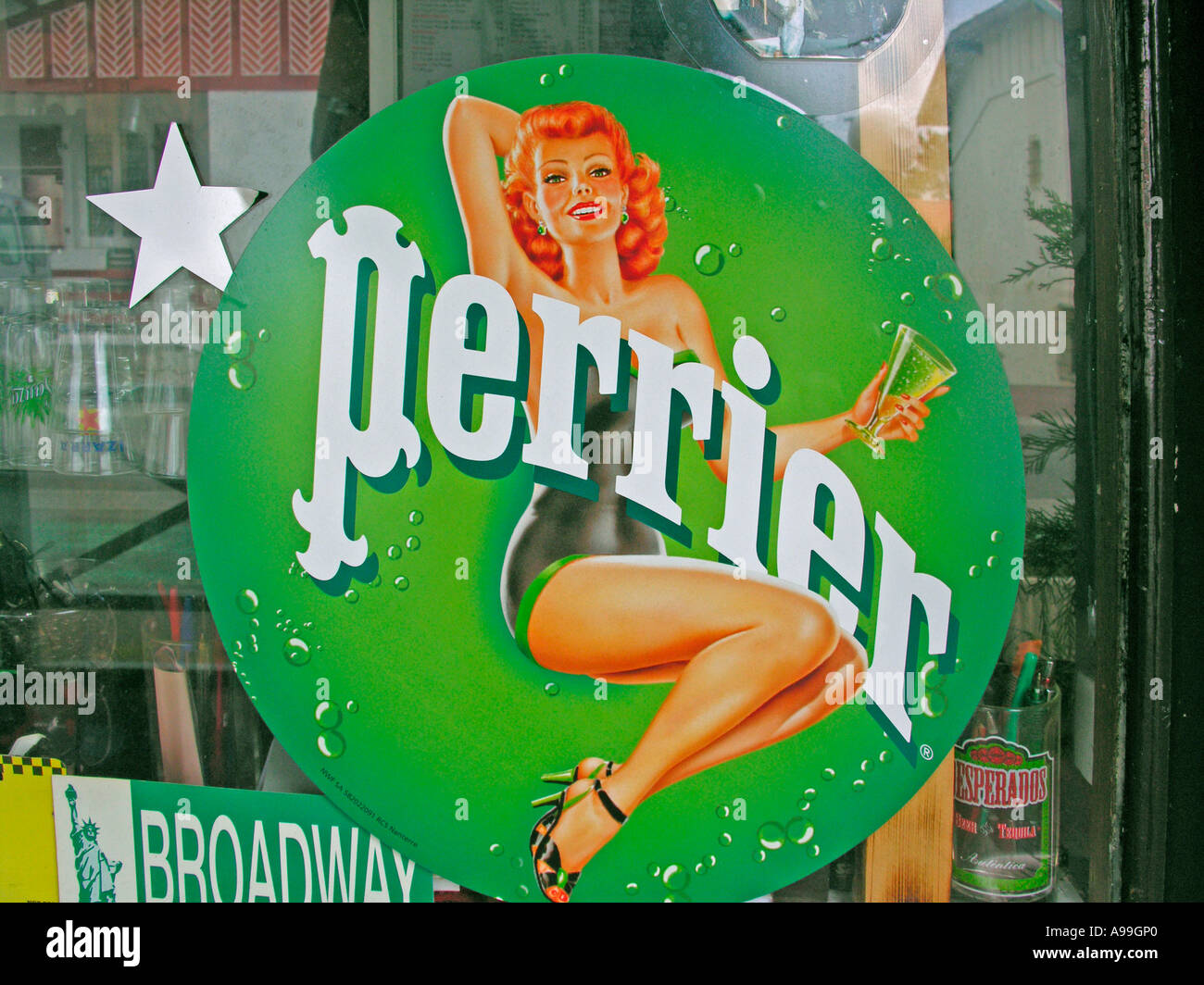old advertising for the mineral water Perrier with a woman in bath dress on glassdoor of a bar Stock Photo