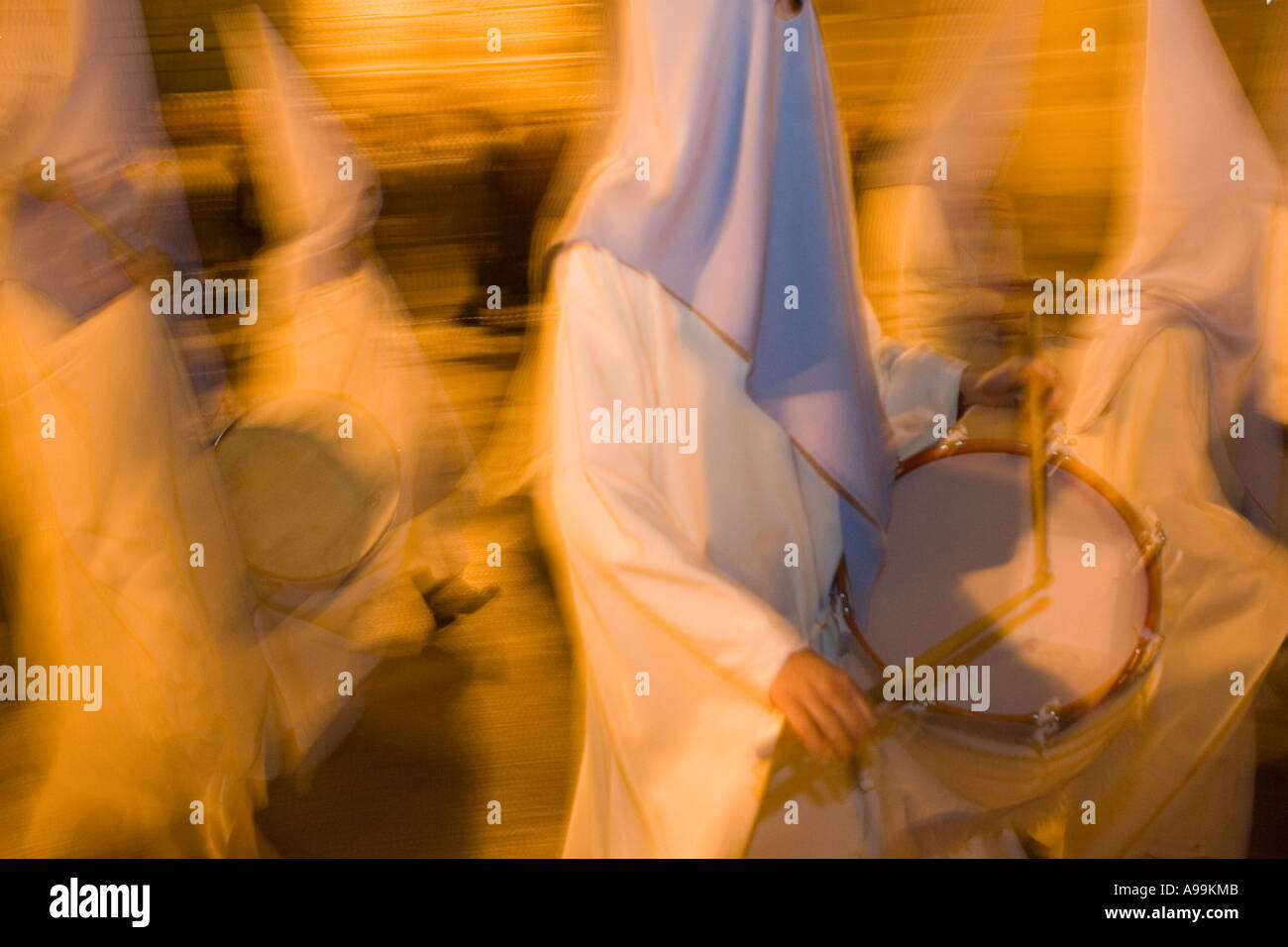 Hooded religious penitents play musical instruments during Holy Week ...