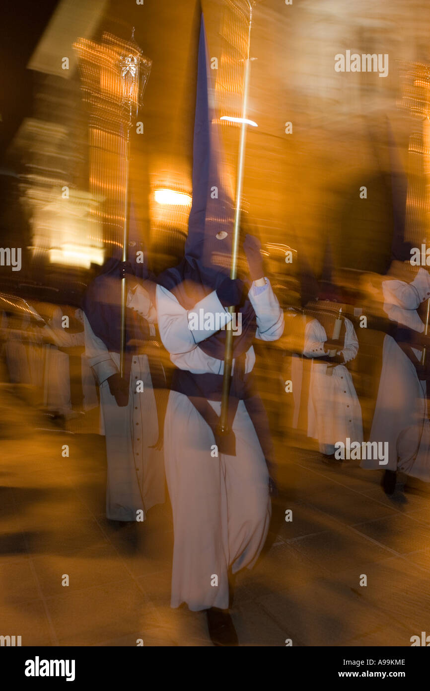 Hooded religious penitents play musical instruments during Holy Week ...