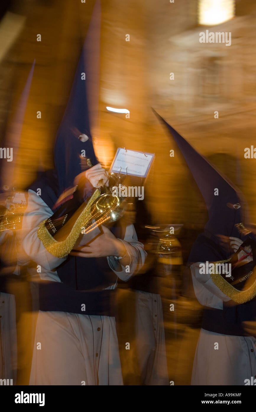 Hooded religious penitents play musical instruments during Holy Week ...