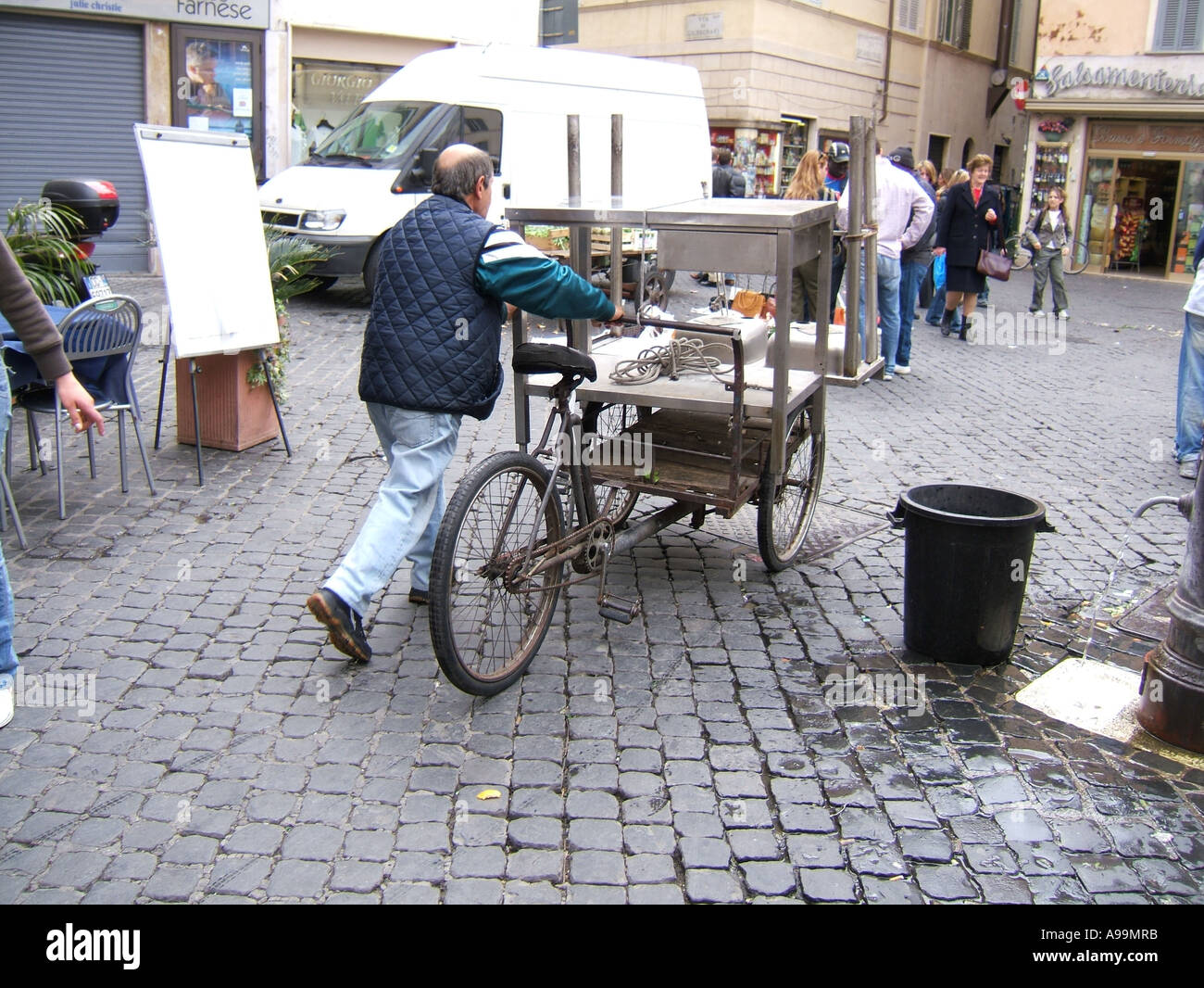 man pushing trolley bike in campo de fiori rome Stock Photo - Alamy