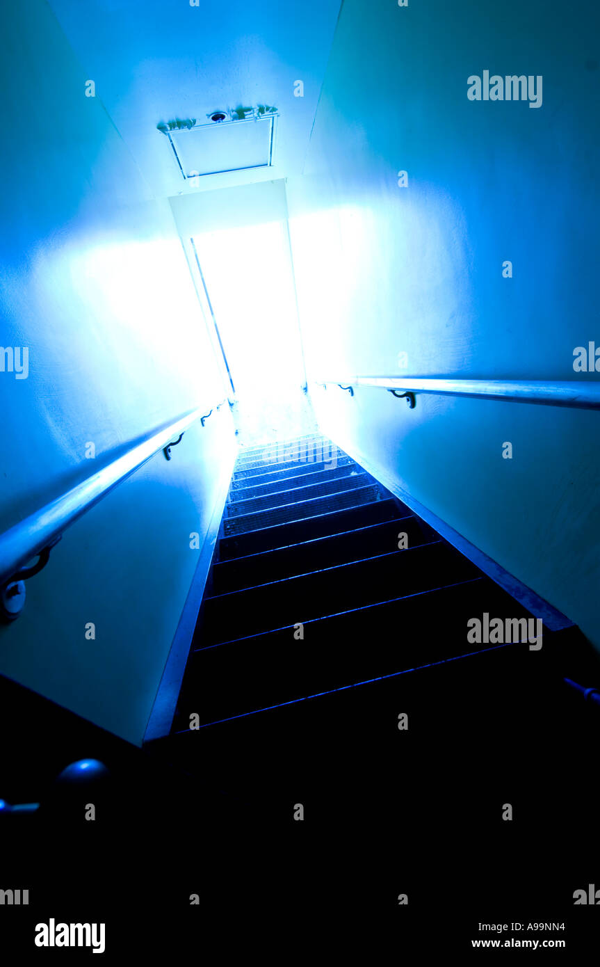 Bright light coming through doorway at the bottom of stairs. Stock Photo