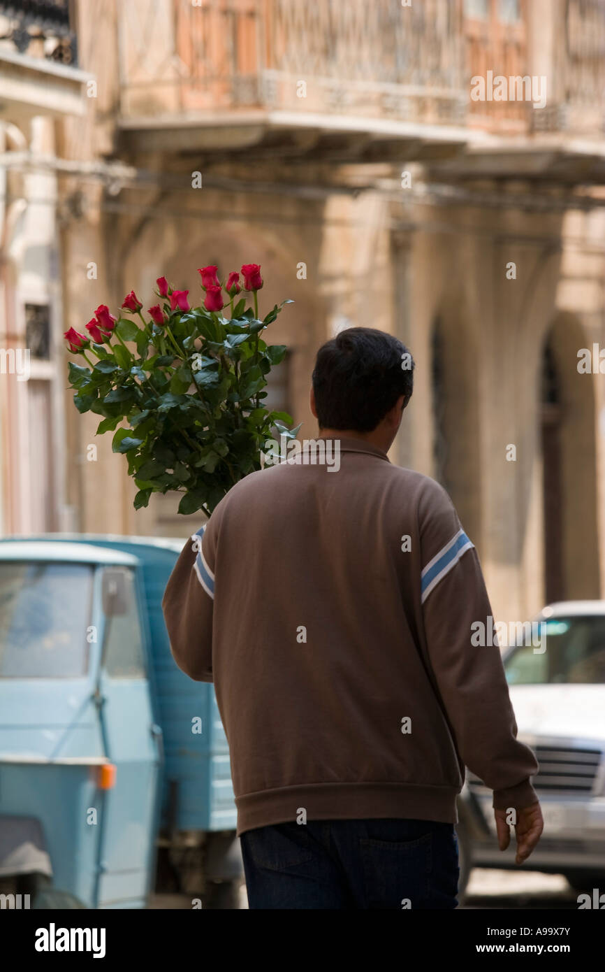 Man Carrying Roses Man carrying bunch of red roses on street Cefalu Sicily Italy Stock ...