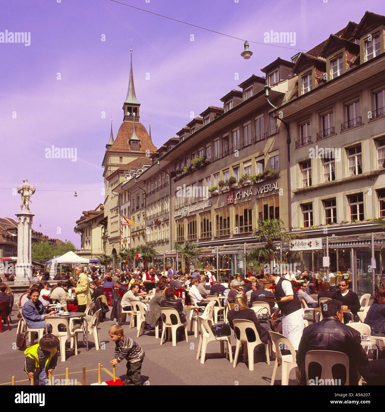 People tourists and city workers at lunchtime sitting outside at a café on Barenplatz in city center of Bern Switzerland Stock Photo