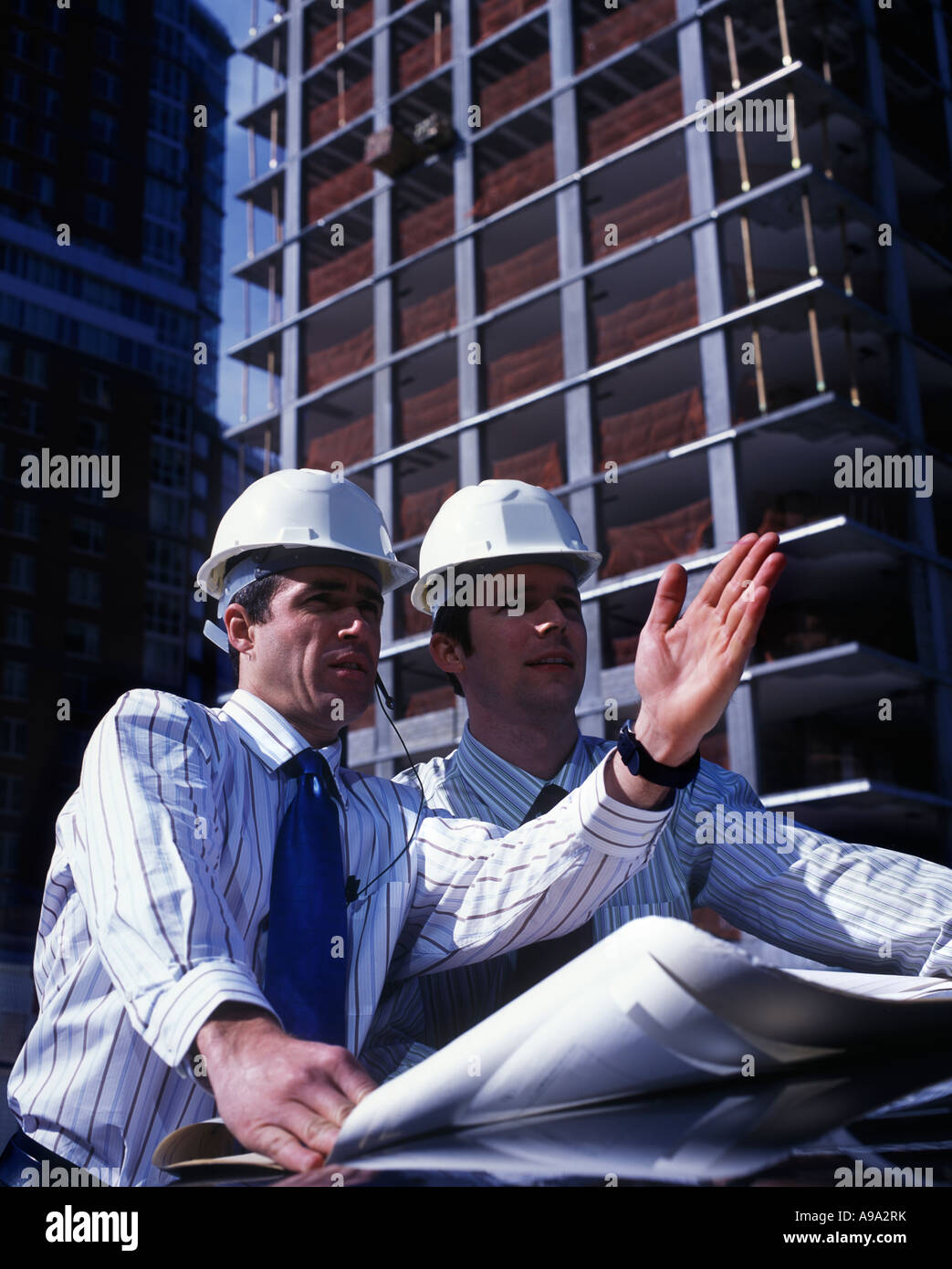 CONSTRUCTION MANAGER AT BUILDING SITE HOLDING BLUEPRINTS Stock Photo ...