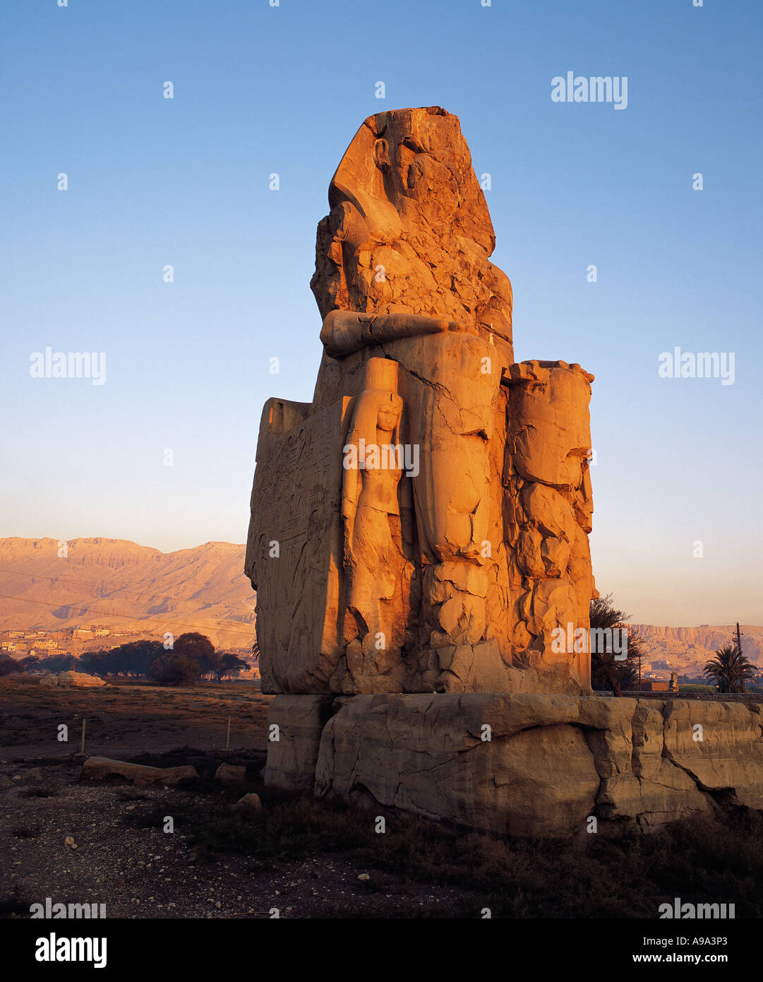 Early morning light on one of the two Colossi of Memnon near the Valley of the Kings Luxor Egypt Stock Photo