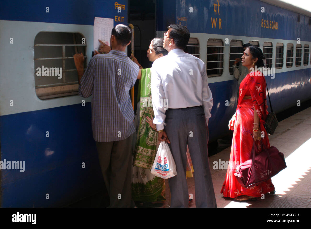 Passengers check seating plan for train, Jaipur Junction station, Rajasthan, India Stock Photo