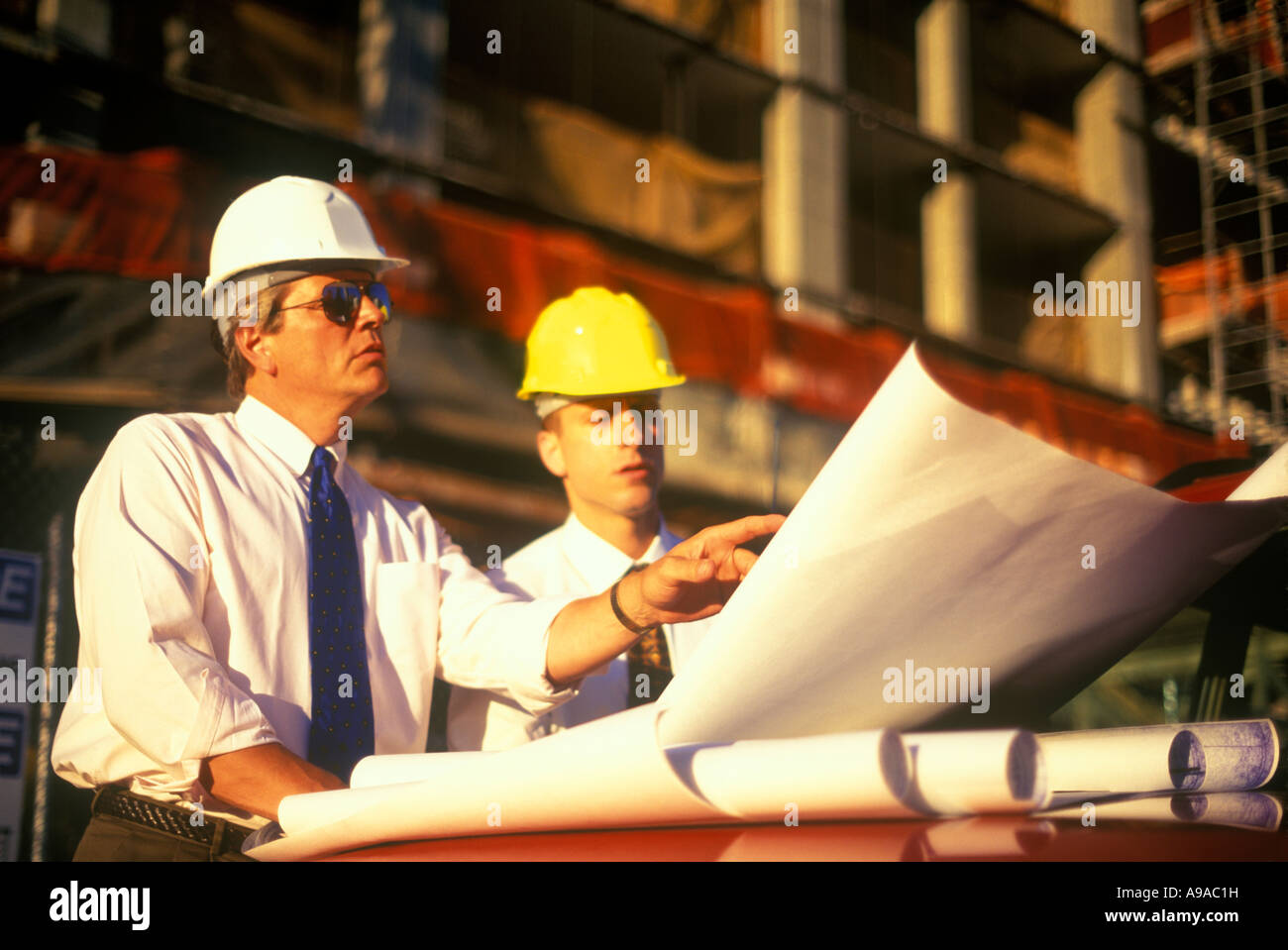 COMMERCIAL CONSTRUCTION WORKERS WITH PLANS CALCULATOR Stock Photo Alamy